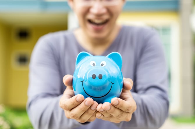 happy-asian-man-holding-blue-piggybank-2024-10-18-10-00-36-utc